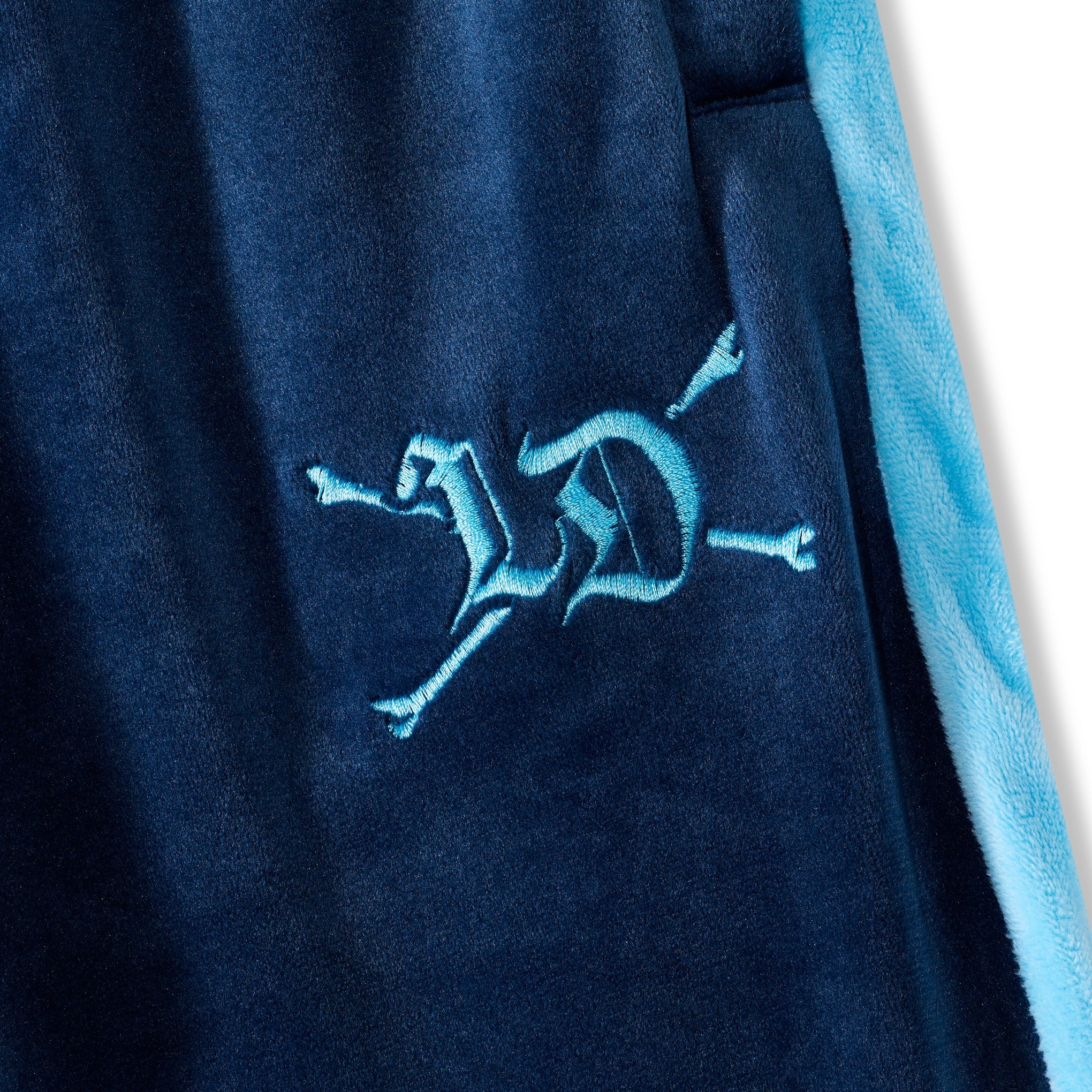 Navy blue fabric with a blue embroidered logo on a white background