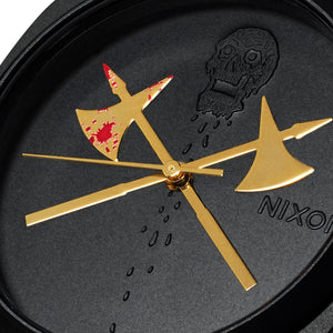 Nixon clock with gold axes and a skull design on a black background