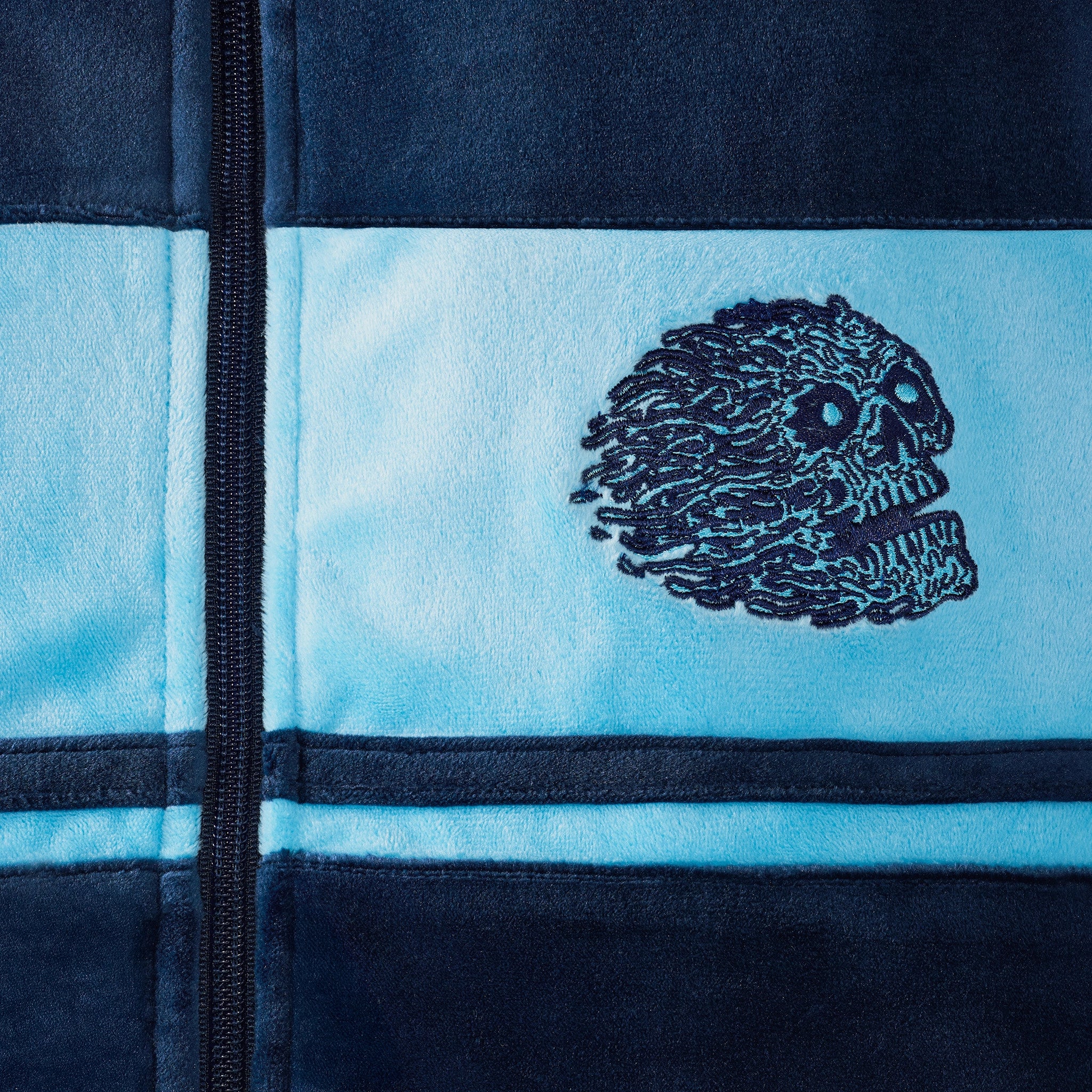 Embroidered skull design on a blue and black fabric background