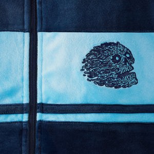 Embroidered skull design on a blue and black fabric background