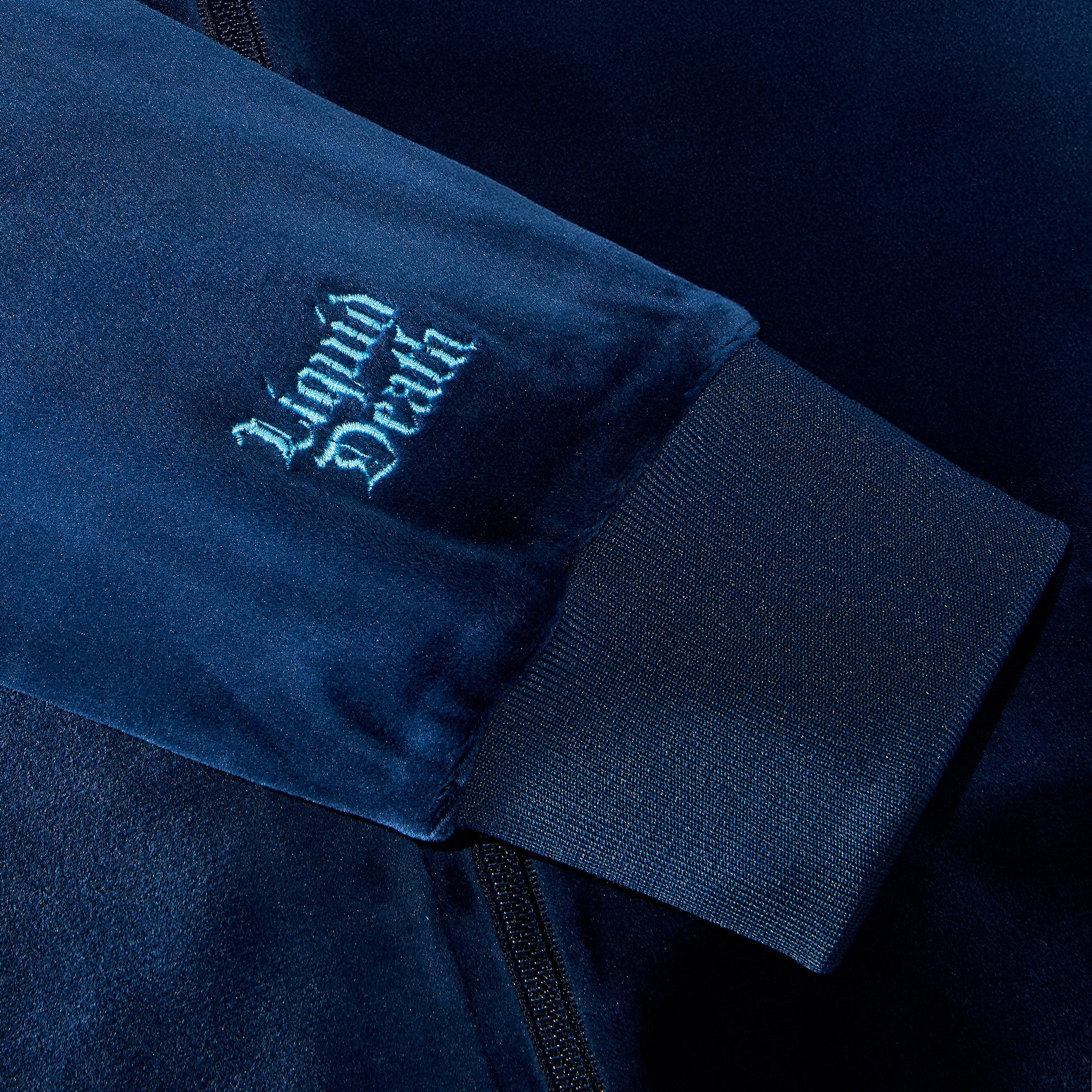 Navy blue jacket with 'Liquid Death' logo on sleeve