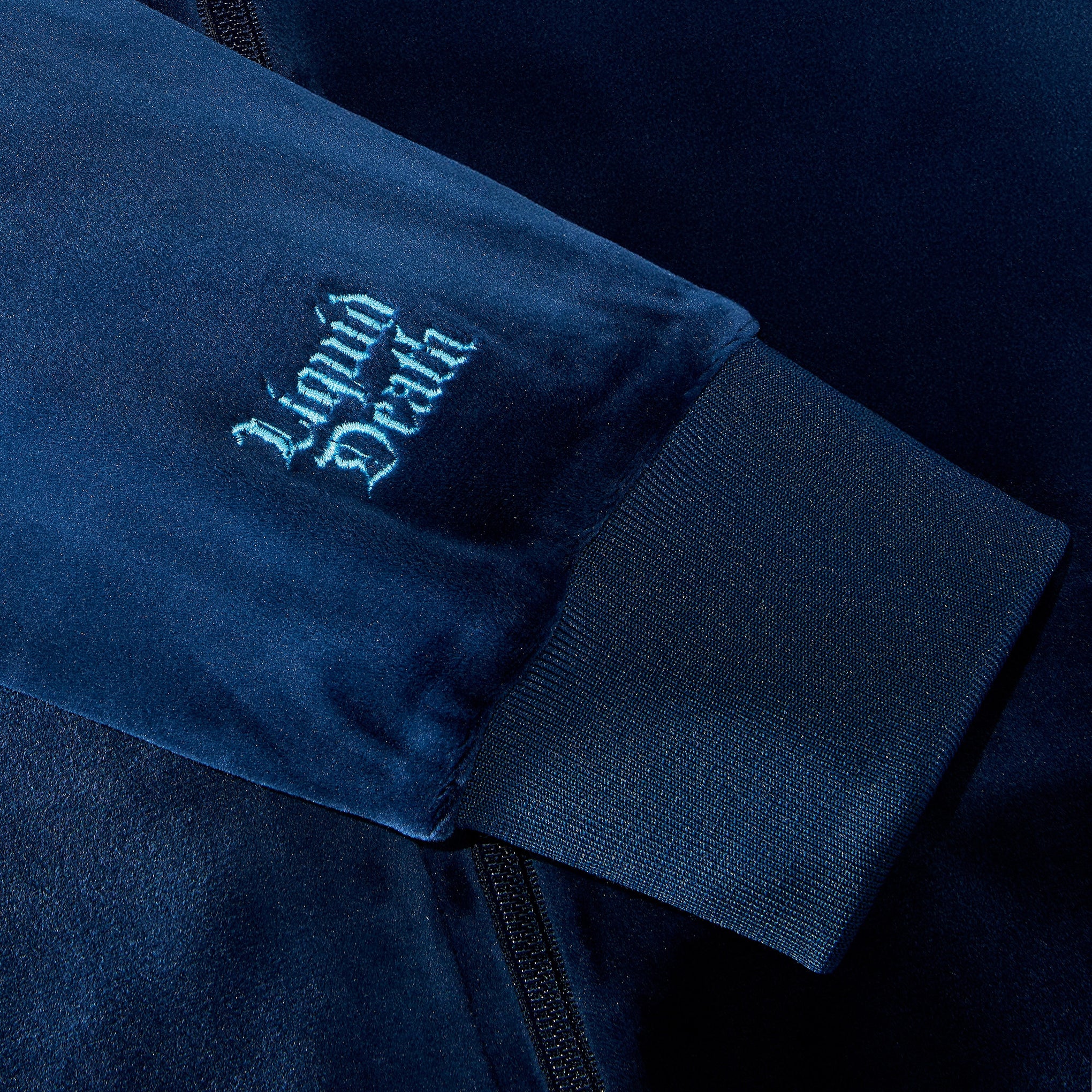 Navy blue jacket with 'Liquid Death' logo on sleeve