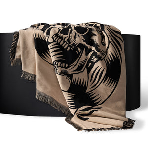 Beige blanket with black elephant design draped over a black surface