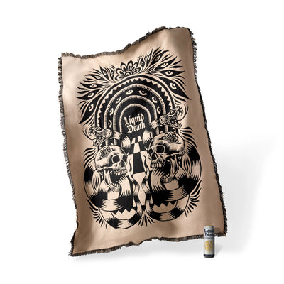 Decorative pillow with skull design and 'Liquid Death' text on a beige background
