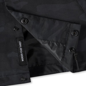 Close-up of a black jacket with buttons and a visible brand label on a white background